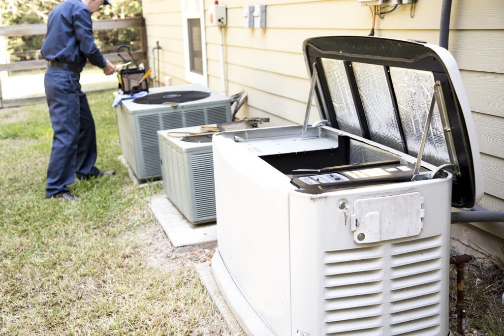 Senior Adult air conditioner Technician/Electrician services outdoor AC unit and the Gas Generator.